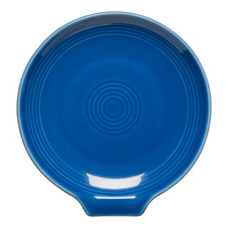The Fiesta Extra Large Spoon Rest 7 Inch in Lapis is a round, deep blue ceramic plate with circular ridges and a small tab, shown from above on a white background—ideal for holding kitchen utensils.