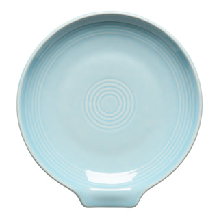 The Fiesta Extra Large Spoon Rest 7 Inch in Sky is a round, light blue ceramic plate with concentric circles and a small flat tab—ideal as a stylish utensil holder or spoon rest for your kitchen.