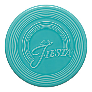 The Fiesta Extra Large Trivet 8 1/4 Inch in turquoise features concentric circular ridges and a stylized Fiesta logo, offering heat resistance and stylish function for your table setting.