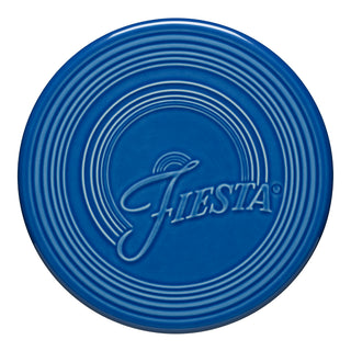 The Fiesta Extra Large Trivet (8 1/4 Inch) in Lapis features concentric circles and "Fiesta" script, making it a stylish, heat-resistant addition to your table.