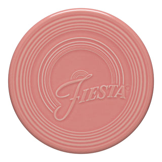 The Fiesta Retired Extra Large Trivet, 8 1/4 inch in Peony, features concentric embossed rings and "Fiesta" in cursive—ideal for stylishly protecting surfaces.
