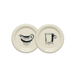 Set of two cream-colored, round coasters from Fiesta, each featuring a vintage-inspired black illustration.