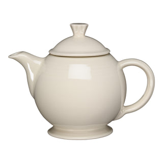 The Fiesta Retired 44 OZ Covered Teapot in Linen features a round body, curved handle, short spout, and fitted lid. Made from lead-safe china, it's dishwasher safe and is shown against a white background.