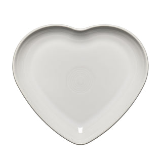 The Retired Fiesta 9 Inch Heart Shaped Plate by Fiesta is a white ceramic plate with subtle concentric circles and a glossy finish, perfect as a serving plate or elegant trinket dish.