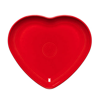The Retired Fiesta 9 Inch Heart Shaped Plate by Fiesta features a scarlet ceramic design with curved edges and subtle concentric circles, ideal as a serving plate or trinket dish, shown on a white background.