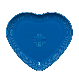 The Retired Fiesta 9 Inch Heart Shaped Plate by Fiesta features a lapis blue color with concentric circular ridges. Made in the USA, it is shown on a white background.