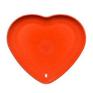 The Retired Fiesta 9 Inch Heart Shaped Plate by Fiesta features a poppy red color and concentric circular patterns, is crafted from lead-safe china, and is shown on a white background.