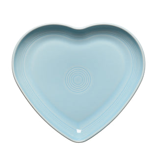 The Retired Fiesta 9 Inch Heart Shaped Plate by Fiesta features a sky blue color and subtle concentric circle patterns at the center and rim.