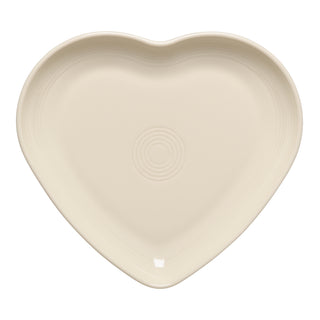 The Retired Fiesta 9 Inch Heart Shaped Plate by Fiesta comes in Linen, featuring a smooth surface and central concentric circles—ideal as a serving plate or trinket dish, displayed from above on a white background.
