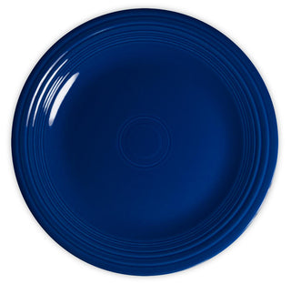 A round, solid dark blue ceramic plate with a glossy finish and concentric circular ridges along the rim, photographed from above on a white background.