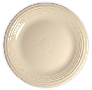 A round, cream-colored ceramic plate with a smooth surface and concentric raised rings near the rim, viewed from above on a white background.