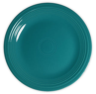A round, teal ceramic plate with a glossy finish and concentric raised rings near the rim, viewed from above against a white background.