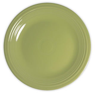 A round, light green ceramic plate with a glossy finish and subtle concentric ridges near the edge, shown from a top-down view on a white background.
