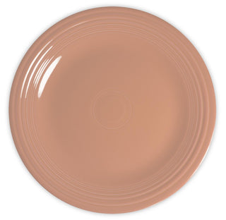 A round, light brown ceramic plate with a glossy finish and concentric circular ridges along the rim, viewed from above on a white background.