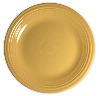 A round, yellow ceramic plate with a glossy finish and concentric circular ridges near the rim, viewed from above on a white background.