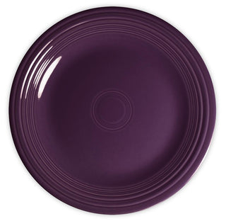 A round, deep purple ceramic plate with a glossy finish and concentric circular ridges along the rim, viewed from above on a white background.