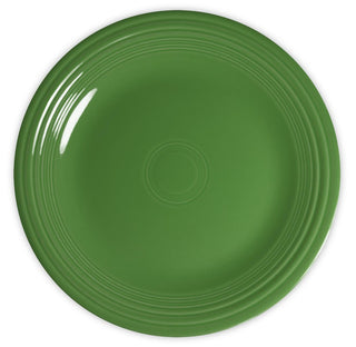 A round, solid green ceramic plate with concentric circular ridges along the edge, viewed from above on a white background.