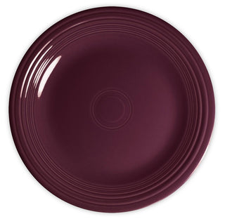 A round, deep purple ceramic plate with concentric circular ridges along the edge, shown from above on a white background.
