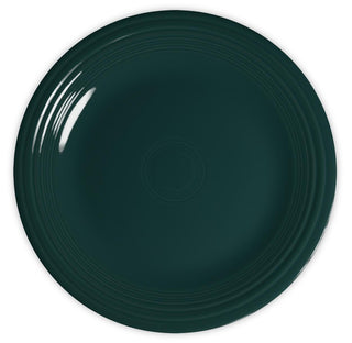 A dark green ceramic plate with a glossy finish and concentric raised rings along the rim, viewed from above on a white background.