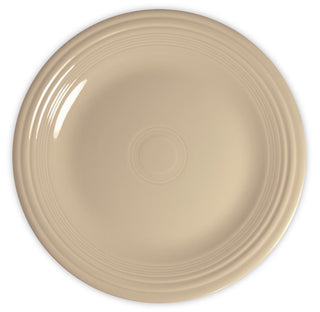 A plain, round beige ceramic plate with a glossy finish and concentric raised rings along the rim, viewed from above against a white background.