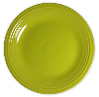 A bright green, round ceramic plate with concentric circle patterns near the rim, viewed from above on a white background.