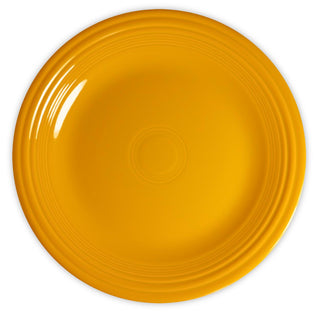 A round, bright yellow ceramic plate with a glossy finish and subtle concentric ridges near the rim, shown from a top-down view against a white background.