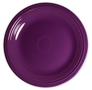 A round, deep purple ceramic plate with concentric circle patterns near the rim, photographed from above against a white background.
