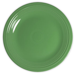 A plain, round, green ceramic plate with a glossy finish and subtle concentric circle patterns near the rim, viewed from above on a white background.
