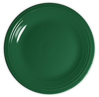 A round, dark green ceramic plate with concentric ridges along the edge, viewed from above against a white background.