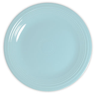 A round, light blue ceramic plate with a glossy finish and concentric circular ridges near the rim, viewed from above on a white background.