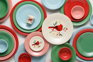 Cheerfully arranged, the plates and bowls in vibrant shades of red, green, blue, and pink—some adorned with a red cardinal and holly motif on white—overlap in festive style as part of Fiesta’s Jolly Christmas Collection. Complementing the set, the Jolly Christmas Cardinal 1 1/2 OZ Ceramic Shot Glass by Fiesta ties together the holiday pattern for a coordinated seasonal table.
