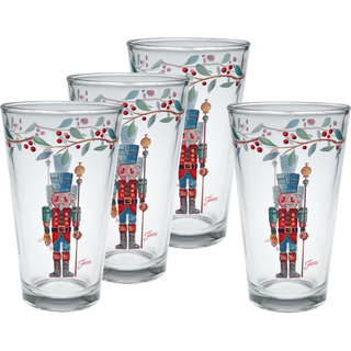 The Moderne Glass Nutcracker The Guardian 16 oz. Cooler Glass Set of 4 features painted nutcracker soldiers and a festive leaf and berry border—perfect holiday tableware or a Christmas dinnerware addition.