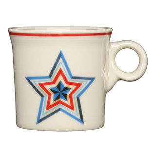 The Fiesta Americana Lapis Faceted Star Classic Ring Handle 10 1/4 OZ Mug features a white ceramic body with a red rim stripe and a bold multi-colored star, making it the perfect patriotic coffee mug for any occasion.
