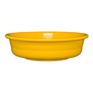 The Fiesta Retired Classic Rim 10 1/2 Inch Extra Large Serving Bowl (80 OZ) in Daffodil features smooth, glossy yellow ceramic sides. Made in the USA and dishwasher safe, it's shown on a white background.