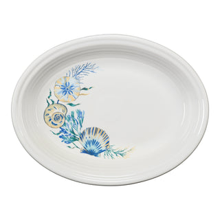 Fiesta Retired Coastal Shores 11 5/8" Medium Oval Serving Platter—white vitrified china, made in the USA, features blue and yellow seashells and seaweed accents along one side.