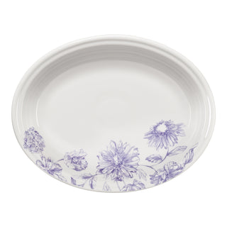The Fiesta Botanical Floral Lavender 11 5/8 Inch Medium Oval Serving Platter is a white ceramic USA-made dish with a purple botanical floral pattern along one edge.