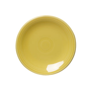 A round, glossy sunflower yellow Fiesta Retired Classic Rim 6 1/8 Inch Appetizer Plate with subtle concentric circles is shown empty, photographed from above on a white background. Dishwasher safe and ideal for appetizers.