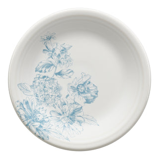 The Fiesta Botanical Floral Sky Classic Rim 7 1/4 Inch Salad Plate is a round white ceramic plate featuring a light blue botanical floral design on one side, with detailed flower and leaf sketches. Made in the USA.