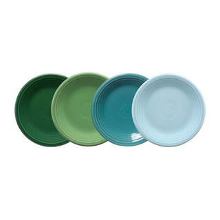 Four Fiesta Mixed Aegean Classic Rim 7 1/4 Inch Salad Plates, set of 4, are arranged in a row on a white background, featuring shades of dark green, light green, turquoise, and light blue for a colorful display.