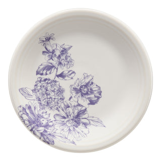The Fiesta Botanical Floral Lavender Classic Rim 7 1/4 Inch Salad Plate is a white ceramic plate with detailed purple floral and leaf designs on one side. Made in the USA.