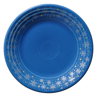 The Fiesta Retired Snowflake Classic Rim 9 Inch Luncheon Plate in lapis features white snowflakes and gold dots along the rim—festive dinnerware made in the USA.