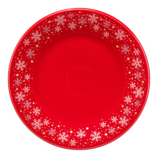 The Fiesta Retired Snowflake Classic Rim 9 Inch Luncheon Plate in scarlet features a white snowflake and gold dot border on a plain red center. This festive dinnerware is made in the USA and is perfect for holiday gatherings.