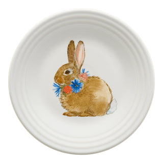 The Fiesta Retired Breezy Floral Easter Classic Rim 9 Inch Luncheon Plate features a brown rabbit with a blue and pink blossom garland, centered on durable vitrified china for lasting beauty.