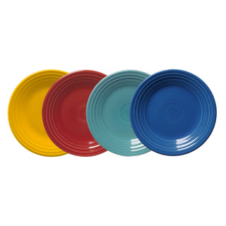 The Fiesta Mixed Vibrant Classic Rim 9 Inch Luncheon Plate Set includes four solid-colored plates—yellow, red, light blue, and dark blue—with simple concentric ridges near the rim. Each plate measures 9 inches across.