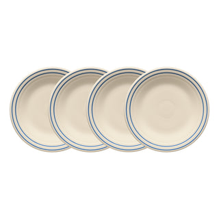 The Fiesta Americana Lapis Band Set includes four 9-inch cream-colored classic rim luncheon plates, each featuring two thin blue bands near the rim. Made in the USA, they’re shown slightly overlapping on a white background.