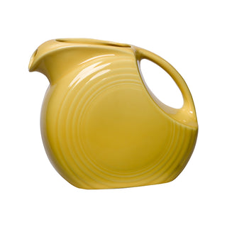 The Fiesta Retired Small Disk Pitcher is a yellow vitrified china pitcher with an Art Deco design, round body, curved handle, spout, and subtle concentric circles. Dishwasher safe.