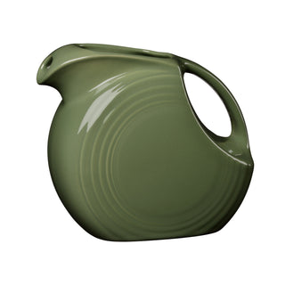 The Fiesta Retired 67 OZ Large Disk Pitcher in sage is a green, round, lead-safe china pitcher with a wide base, curved handle, and spout. It features subtle circular ridges and a glazed finish. Made in the USA; shown on a white background.