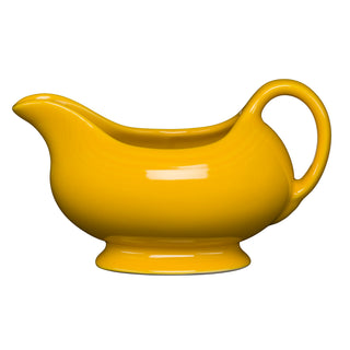 The Retired Fiesta 18 1/2 OZ Gravy Sauceboat in daffodil features a rounded body, wide spout, and curved handle—ideal for serving sauces. Shown against a plain white background.