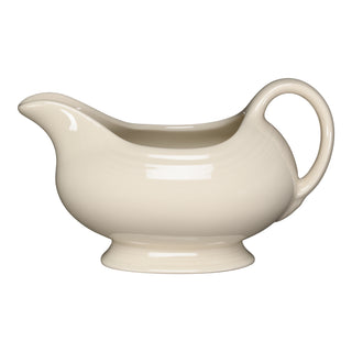 The Fiesta Linen 18 1/2 OZ Gravy Sauceboat features a curved spout, rounded body, and large handle—perfect for serving sauces. Made from lead-safe china with a cream-colored finish called Linen.