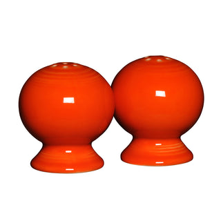 The retired Fiesta 2 5/8 inch salt and pepper shaker set in Poppy features two glossy, round shakers side by side, showcasing the vibrant style classic to Fiesta Dinnerware.